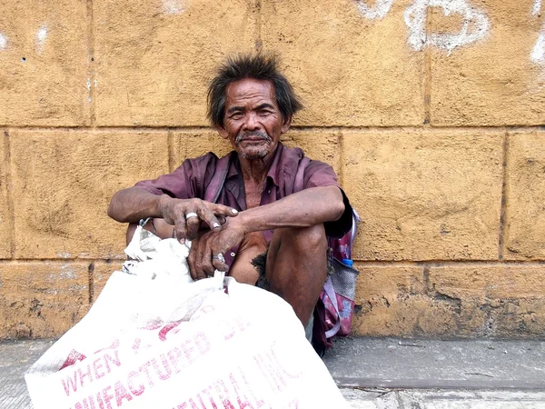 Stary człowiek spoczywa na chodniku na ulicy w Antipolo City w prowincji Rizal, Filipiny — Zdjęcie stockowe