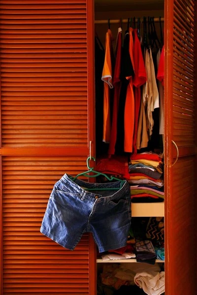 Denim shorts hanging by a clothes cabinet door — Stock Photo, Image