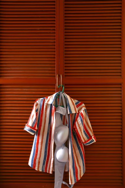 Блузка и бюстгальтер висят у двери шкафа с одеждой — стоковое фото