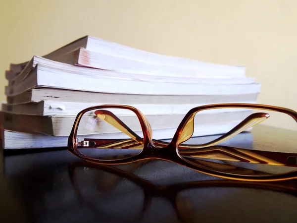 Högen av böcker och ett par glasögon — Stockfoto
