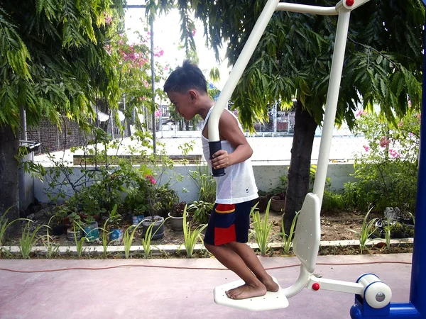 Les jeunes enfants jouent dans un parc extérieur avec des équipements de gymnastique — Photo