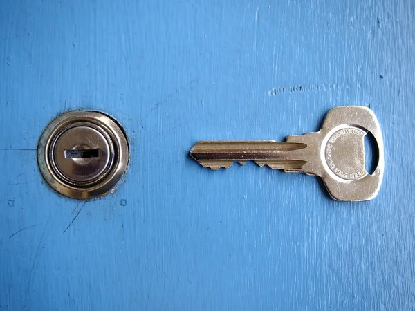 Keys and a keyhole on a blue door — Stock Photo, Image