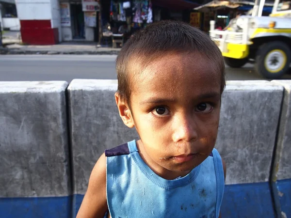 Jeune enfant de la rue regardant la caméra — Photo