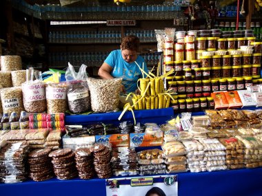 A woman sells a variety of local food clipart