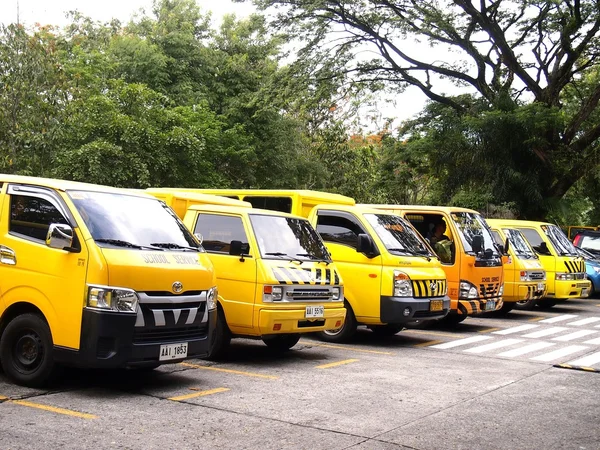 Veículos de serviço escolar estacionados dentro de um estacionamento escolar — Fotografia de Stock
