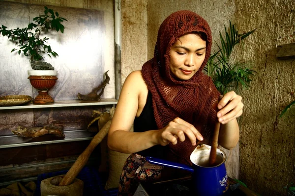 Una mujer prepara la bebida de cacao caliente manualmente de granos de cacao recién molidos . — Foto de Stock