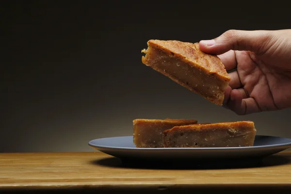 Hand getting a freshly baked Filipino sweet bread called "puding" — Stock Photo, Image