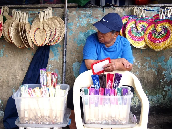 Уличный торговец продает разноцветные ручные вентиляторы — стоковое фото