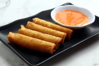 Lumpiang Shanghai adlı taze pişmiş Filipinli yemeğin ya da bahar rulosunda kızarmış domuz etinin fotoğrafı..