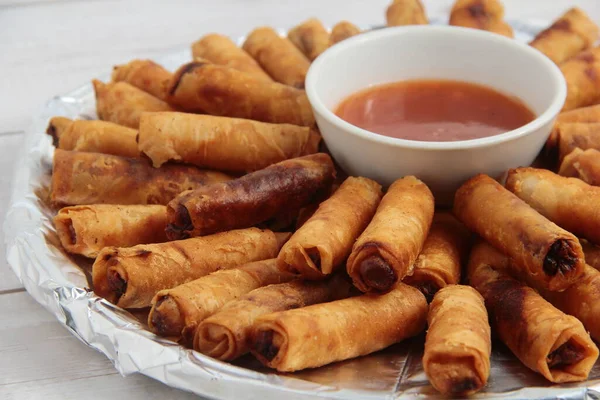 Lumpiang Shanghai adlı taze pişmiş Filipinli yemeğin ya da bahar rulosunda kızarmış domuz etinin fotoğrafı..