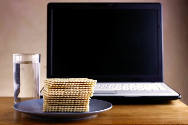 Soda Crackers, Glass of water and a computer — Stock Photo, Image