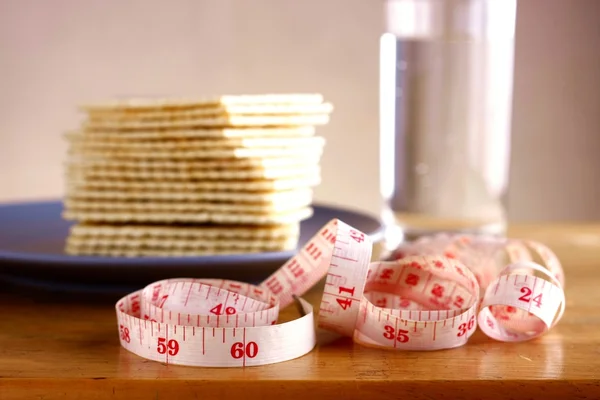 Soda Crackers, Glass of water and a measuring tape — Stock Photo, Image
