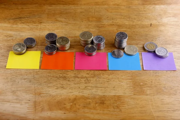 Différentes piles ou piles de pièces avec des étiquettes en papier coloré — Photo