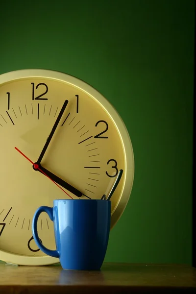 Un reloj analógico y una taza de café azul —  Fotos de Stock