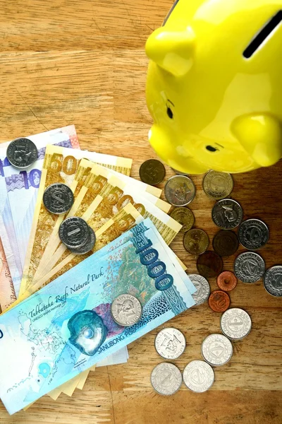 Money Bills and a coin bank on a table — Stock Photo, Image