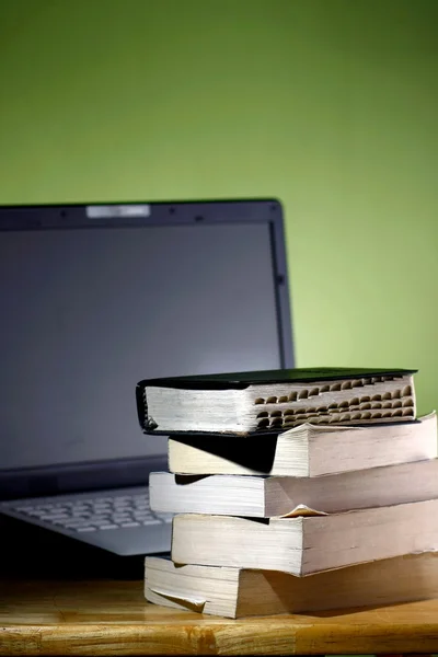 Kitap yığını ve bir dizüstü bilgisayar
