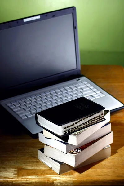 Kitap yığını ve bir dizüstü bilgisayar