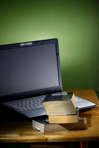 Une pile de livres et un ordinateur portable — Photo