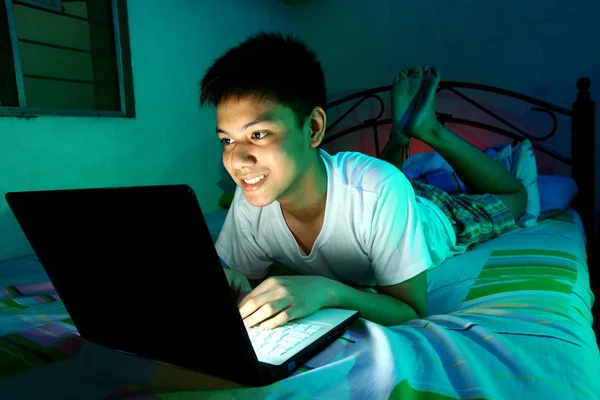 Młoda nastolatka przed komputerem laptop i na łóżku — Zdjęcie stockowe