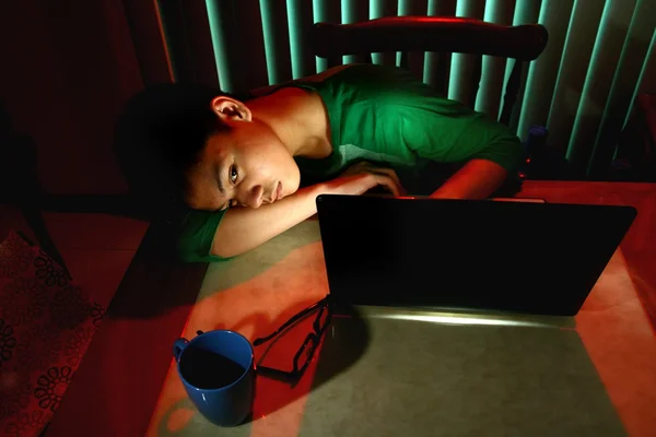 Junger Teenager schläft vor einem Laptop — Stockfoto