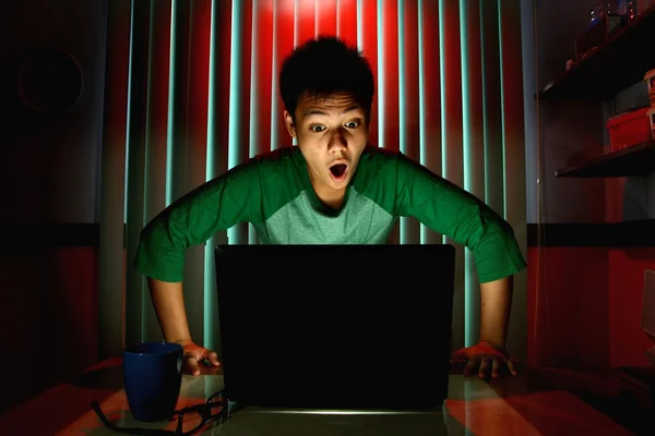 Young Teen with eyeglasses acting surprised in front of a laptop computer — Stock Photo, Image