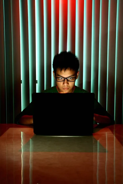 Adolescente joven con gafas en frente de una computadora portátil — Foto de Stock