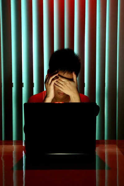 Jovem Adolescente na frente de um computador portátil e cobrindo seus olhos — Fotografia de Stock