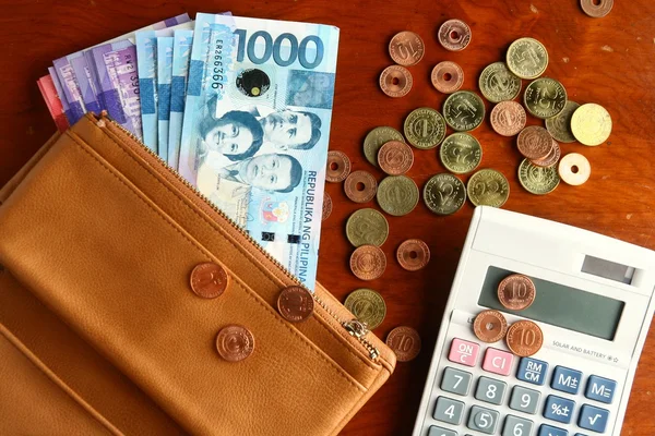 Cash money in a leather wallet, coins and a calculator — Stock Photo, Image