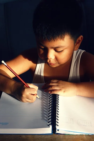 アジアの若い男の子をノートに書く — ストック写真