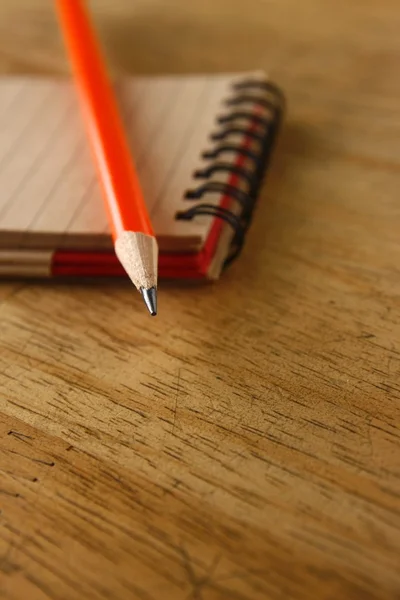 Bir tabloda bir defter ve kalem — Stok fotoğraf