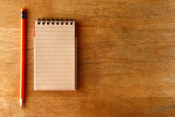 Lápiz y un cuaderno sobre una mesa — Foto de Stock