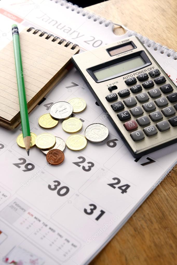 Notebook, calculator, calendar, pencil and coins