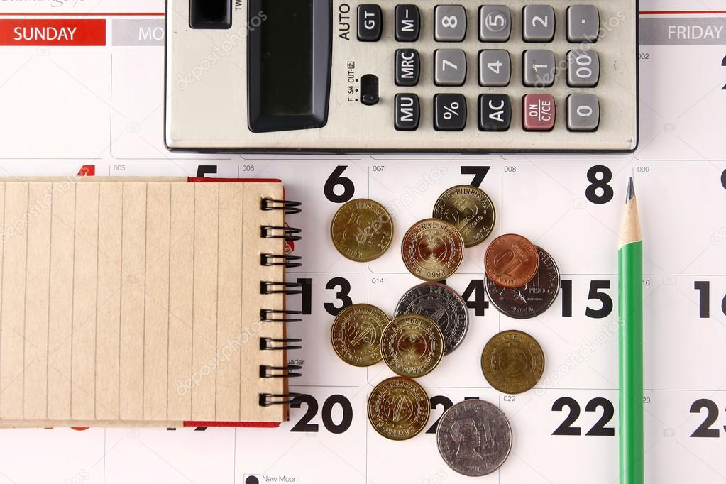 Notebook, calculator, calendar, pencil and coins