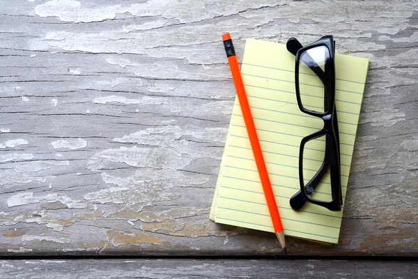 Notepad, eyeglasses and a colorful pencil — Stock Photo, Image