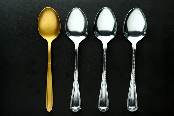 Golden Spoon among ordinary spoons — Stock Photo, Image