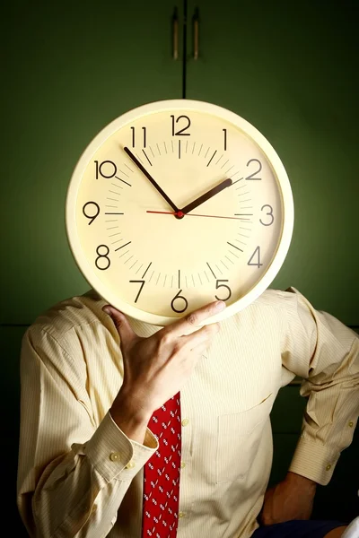 Hombre sosteniendo un reloj en su cara — Foto de Stock