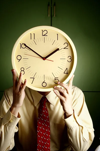 Hombre sosteniendo un reloj en su cara —  Fotos de Stock