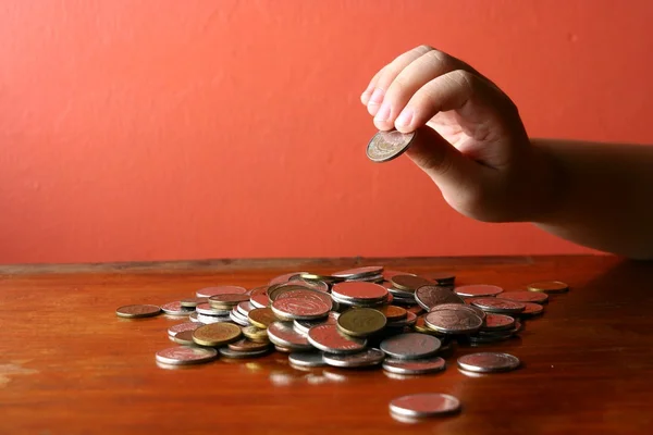 Elegir a mano una moneda de un montón de monedas sueltas —  Fotos de Stock