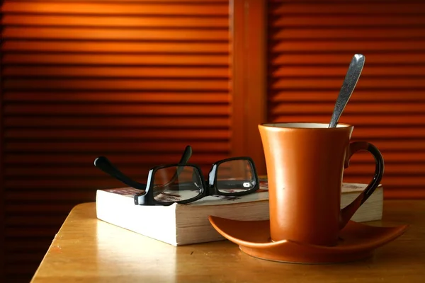 Kubek kawy, okulary i książkę na stole — Zdjęcie stockowe