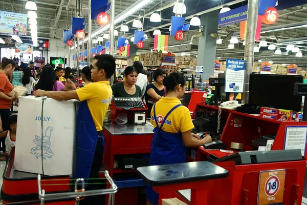 Kassiers en bagger jongens in een supermarkt in de Filippijnen — Stockfoto
