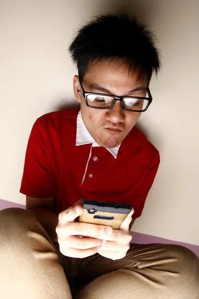 Niño adolescente usando un teléfono inteligente intensamente — Foto de Stock