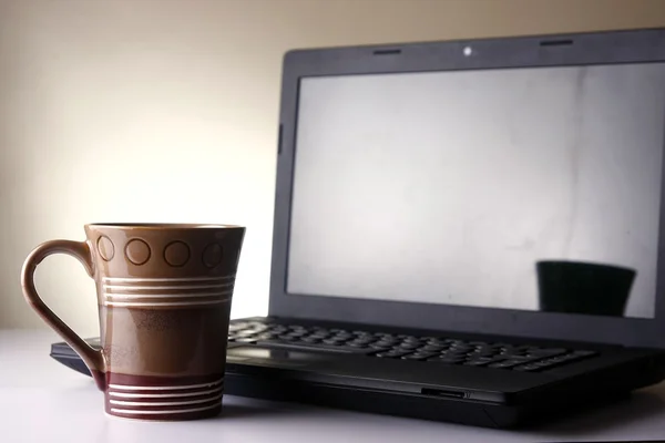 Caneca de café e um computador portátil — Fotografia de Stock