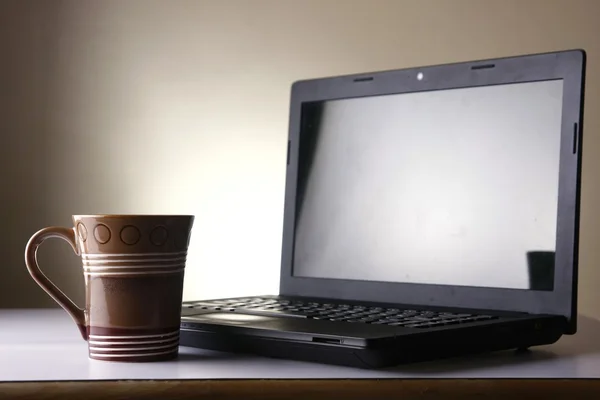 Kaffeebecher und ein Laptop — Stockfoto