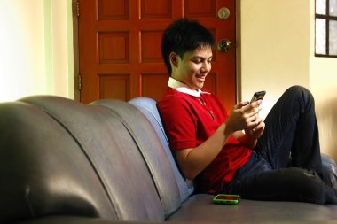 Teen kanepede otururken bir smartphone kullanarak