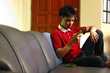 Teen kanepede otururken bir smartphone kullanarak