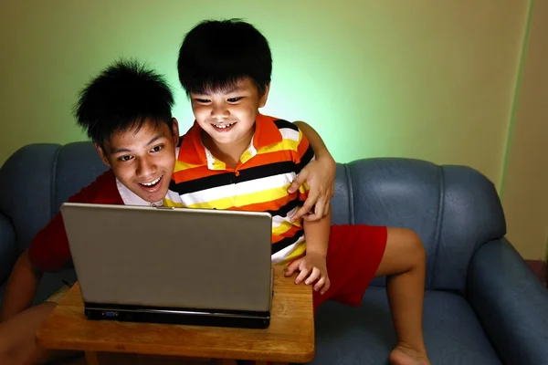 Doi băieți tineri care folosesc un laptop și zâmbesc — Fotografie, imagine de stoc