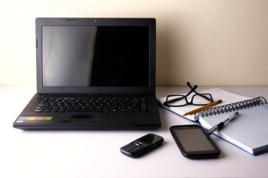 Dizüstü bilgisayar, cep telefonu, akıllı telefon, defter, kalem, kurşun kalem ve gözlük