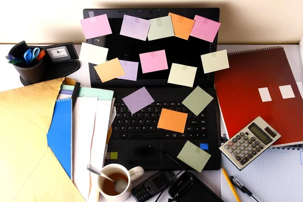 Laptop-Computer mit bunten Papieren, Handy, Smartphone, Notizbuch, Stift, Bleistift und Brille — Stockfoto