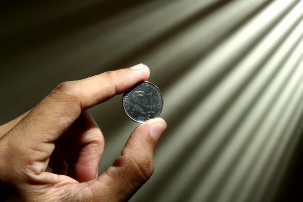 Mano sosteniendo una moneda — Foto de Stock