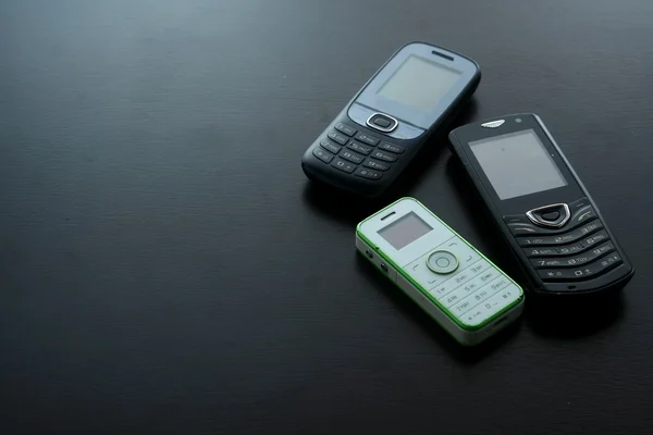 Классические или старые мобильные телефоны на деревянном столе — стоковое фото